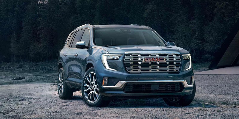 GMC Acadia SUV parked in outdoor forest setting